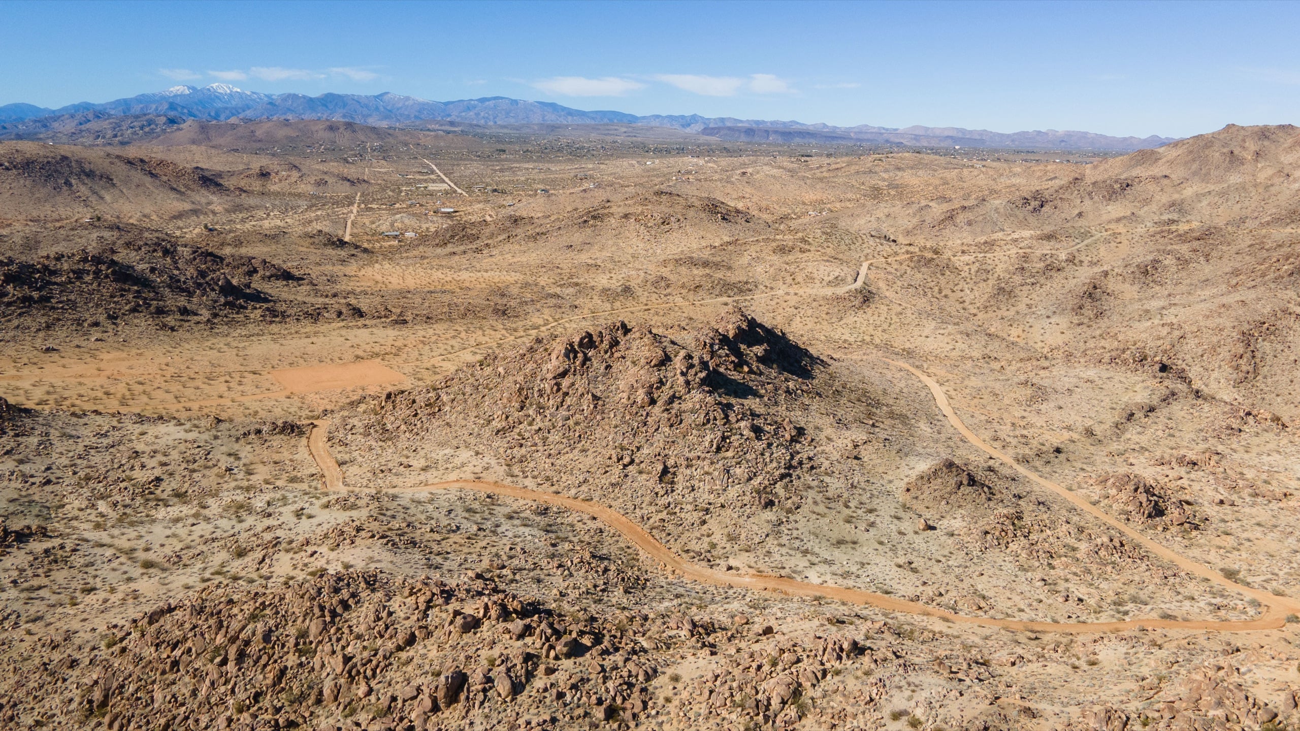 An aerial view over the property, showing rock formations and endless valley beyond