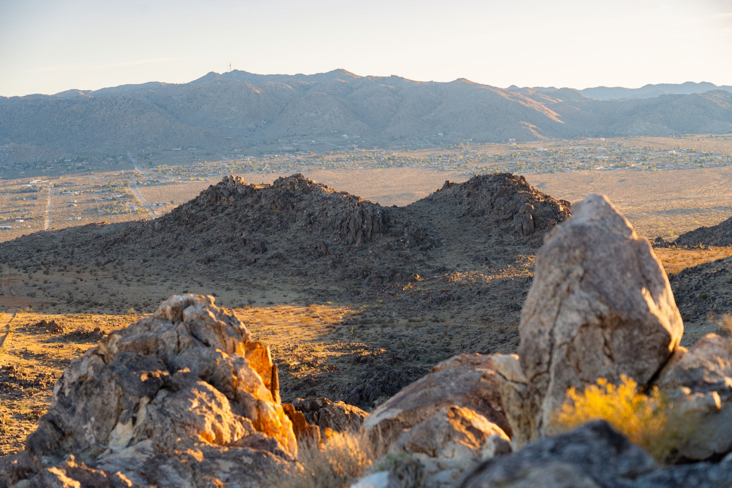 Weathered rocks in the foreground with the Coachella Valley stretching to the mountains beyond