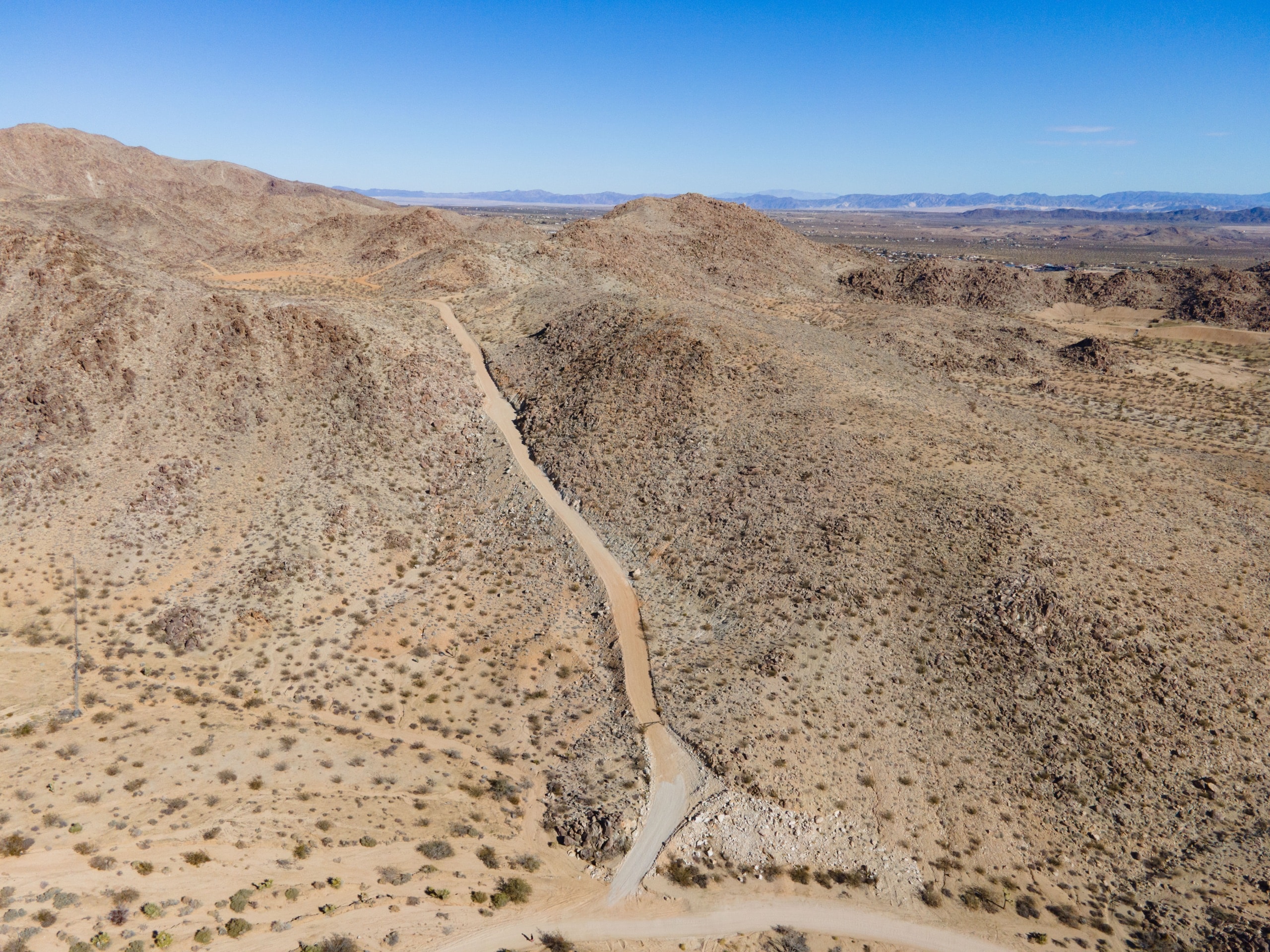 The private drive climbing toward the graded homesite with valley and mountains beyond